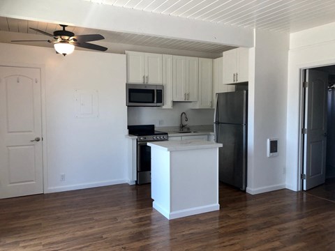 a kitchen with an island and a stainless steel refrigerator